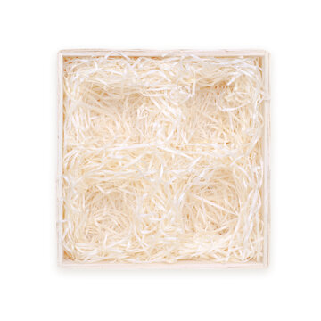 Top view of wooden box for eco gift filled with decorative shredded white paper with four holes for gifts. Isolated on white, clipping path included.