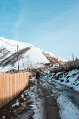 A young woman moves on the streets of Ushguli village in the winter in Georgia