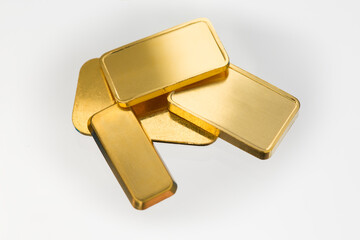 Gold bricks, white background, light reflections