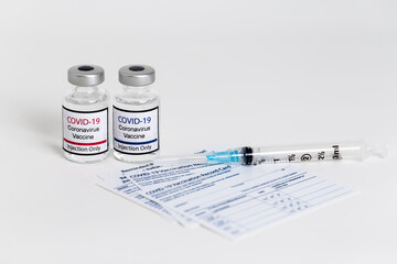 Covid-19 vaccine and syringe on white background.