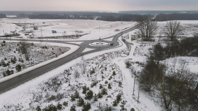 aerial of cars moving around the ring outside the city in winter