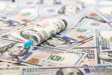 Syringe with 100 dollar banknote inside on dollar banknotes