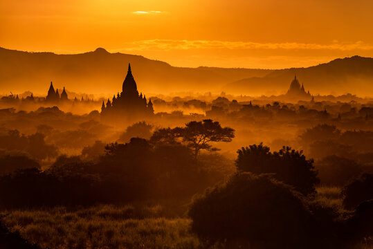 MYAUKI GUNI TEMPLE, SUNSET, TEMPLES OF BAGAN, MYANMAR - 25 November 2016: Sunset across many temple roofs shot in west direction from  Pyathetgyi Pagoda roof top.