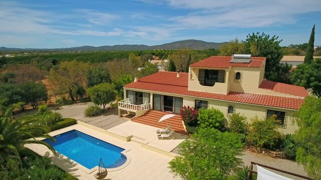 Aerial video of private luxury villa, a delightful pool and some nice green vegetation.