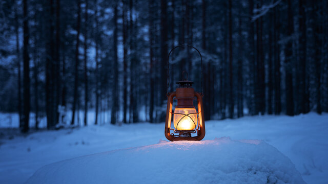 Vintage burning lantern on snow. Dark forest on background. Night forest. Winter season. Copy space.
