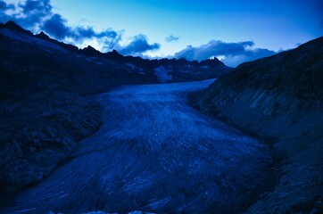 Fototapeta premium fantastic view of the great rhone glacier by night and the mountains in the canton of valais. Eternal ice near the Furka Pass, Switzerland. Viewpoint