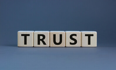 Trust symbol. Concept word 'trust' on wooden cubes on a beautiful grey background. Business and...