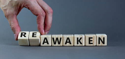 Reawaken symbol. Businessman turns cubes and changes the word 'awaken' to 'reawaken'. Beautiful grey background, copy space. Business and reawaken or awaken concept.