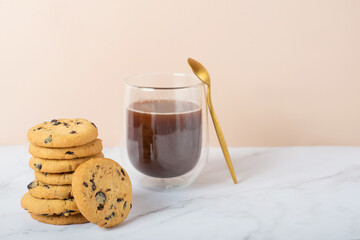 cookies with chocolate drops and coffee on a white table