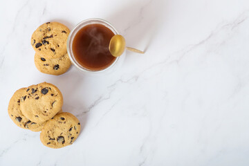 cookies with chocolate drops and coffee on a white table