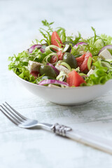 Salad with Green Olives, Tomatoes and Feta Cheese. Bright wooden background. Copy space.