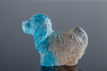 beautiful statuette of a dog from the mineral topaz on a gray background