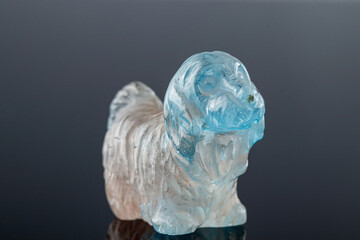 beautiful statuette of a dog from the mineral topaz on a gray background