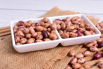 Natural bean grains, Phaseolus vulgaris on wooden background with light veins
