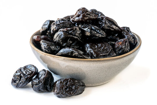 Bowl of Fresh Pitted Prunes over White Background
