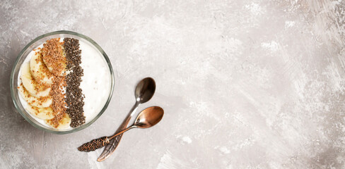 Milk chia pudding with fruits and seeds on a concrete background with copy space.