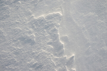 The texture of white snow in the cold. Pattern on a snowy surface.