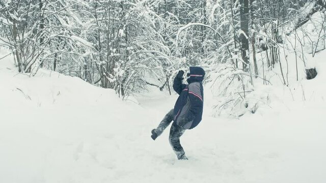 In winter, a robot with plastic face and black glasses walks through snow. Android falls and tries to get up. Concept of parody, humor, and cyberpunk