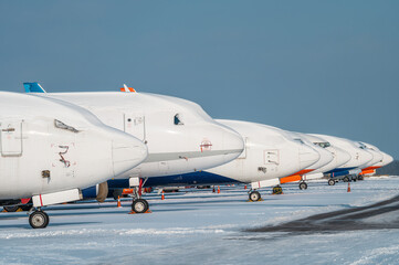 Modern passenger airplanes on the apron of airport. Airport in snow.