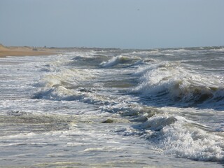 Pieds dans l'eau sur une plage de Vendée avec vagues (vue latérale) 