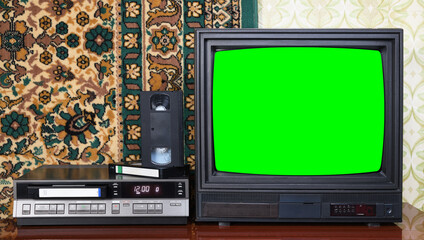 Old black vintage TV with green screen to add new images to the screen, VCR on wallpaper background.