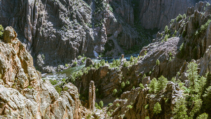 Panorama shot of gunnison river and rocky walls in black canyon of gunnison at sunny day in america