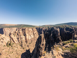 Wide shot of steep rocky walls in black canyon of gunnison at sunny day in america