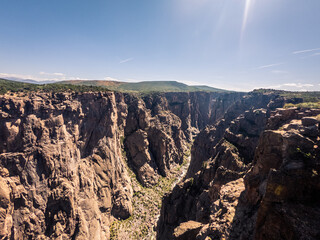 Wide shot of gunnison river and rocky walls in black canyon of gunnison at sunny day in america