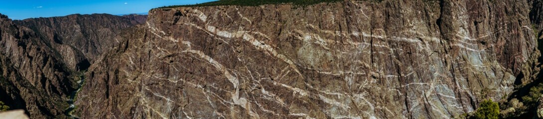 Panorama shot of gunnison river and rocky painted wall in black canyon of gunnison at sunny day in america