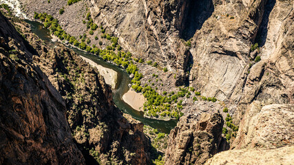 Wide shot of gunnison river and rocky walls in black canyon of gunnison at sunny day in america