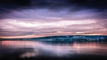 Traumhafter Sonnenaufgang im Winter am schönen Bodensee mit lila Wolken am Himmel 