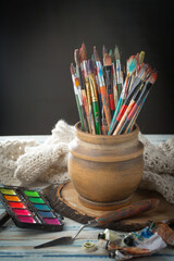 Brushes and paints for painting on an old background.