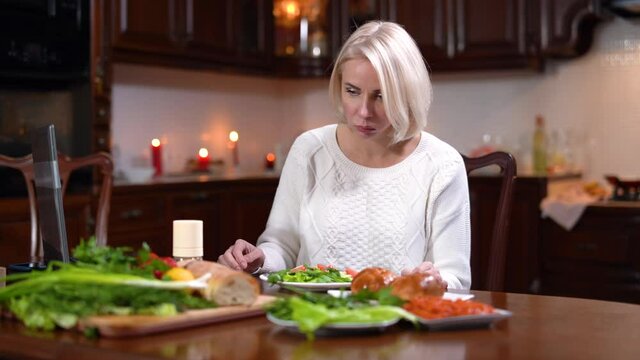 Young Caucasian woman eating salad, feeling nausea, and running away. Portrait of beautiful blond lady vomitting at lunch at home. Health care and medical problems. Indigestion symptoms.