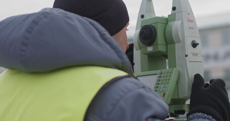 Worker Professional Surveying Engineer in the open space. A professional surveyor takes action with...