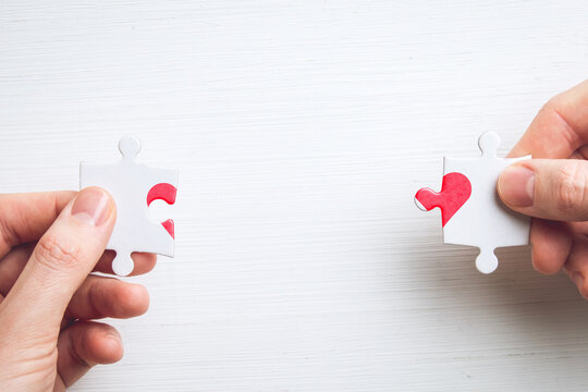 The concept of love and heart in the jigsaw puzzle in hands