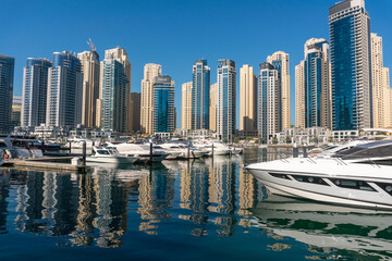 Fototapeta na wymiar Yachts near Embarkment in Dubai Marina. Modern buildings in Dubai, UAE. In the city of artificial channel length of 3 kilometers along the Persian Gulf
