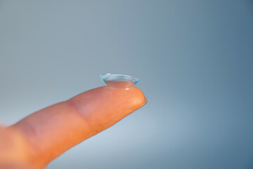 contact lens on the finger on a light background