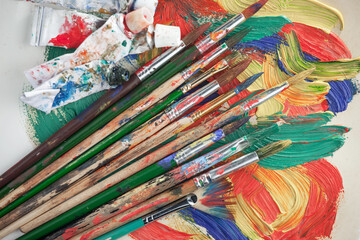 Obraz premium Multi-colored oil paints squeezed out of a tube onto a white sheet of paper.