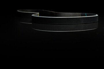 CAR BELT used for car maintenance placed on black reflexive glass isolated on black background 