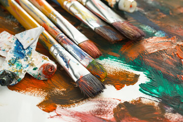 Fototapeta premium Brushes and paints for painting on an old background.