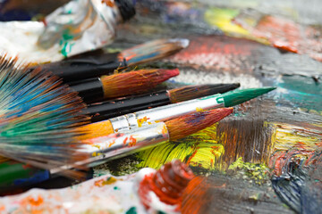 Fototapeta premium Brushes and paints for painting on an old background.