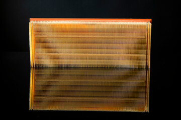 Car AIR FILTER placed on relfective black glass on black background with pattern details