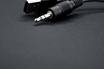 Closeup of a USB aux cable against a black background