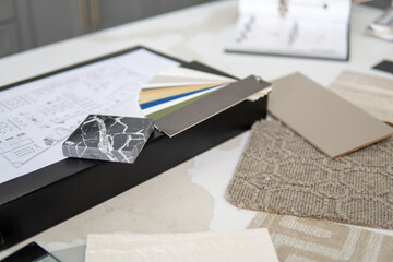 Interior designer's working table, an architectural plan of the house, a color palette, furniture...