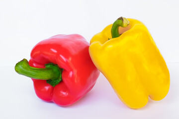 Red, yellow sweet peppers placed on a white background. Close-up view.