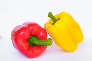Sweet, red, yellow peppers placed on a white background.