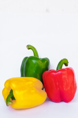 Three-color sweet pepper, red, green, yellow with white background.