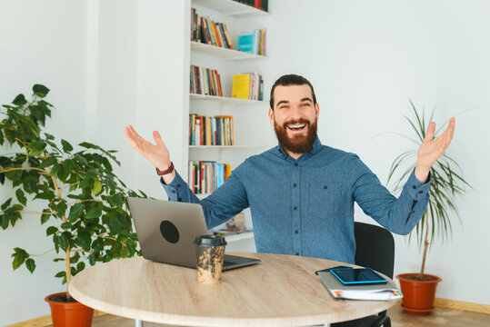 Photo of cheerful office worker making welcome gesture and smiling.