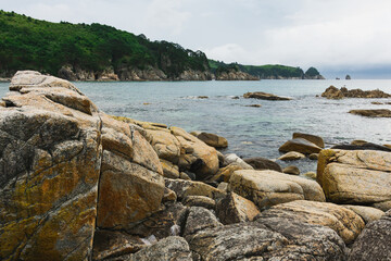 Cloudy summer day on the sea with a rocky shore coastline of the Bay.