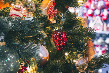 Variety of Christmas tree decorations on a traditional tree for sale.